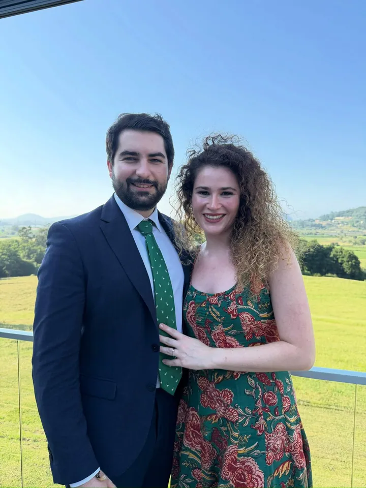 Raquel y Adrián juntos en una terraza con vistas al campo.